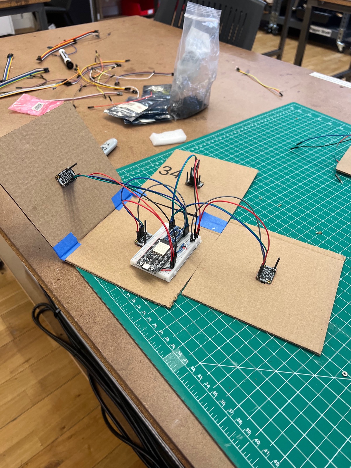 Unfolded cardboard sensor cube with photo sensors and an ESP microcontroller on a breadboard