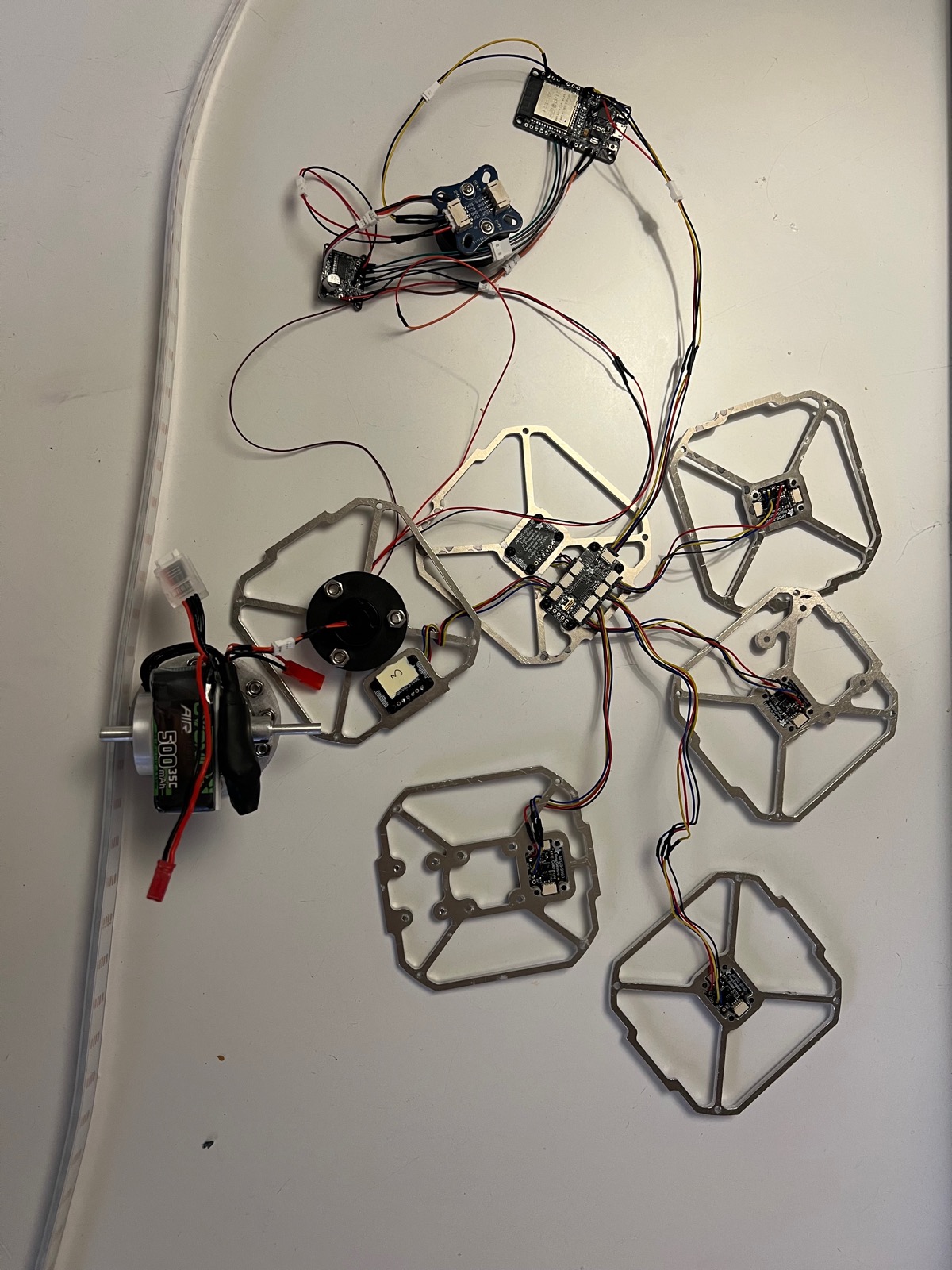 Fully disassembled cube laid out: six frames, the central controller board, and the reaction-wheel motor with battery