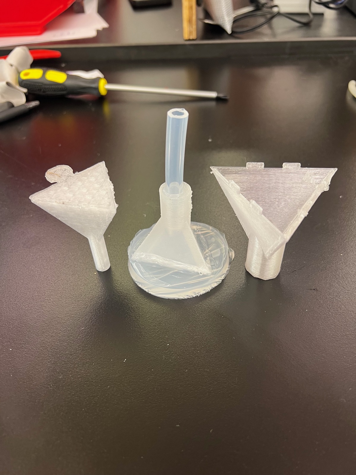 Three funnel-shaped inflatable prototypes on a work table