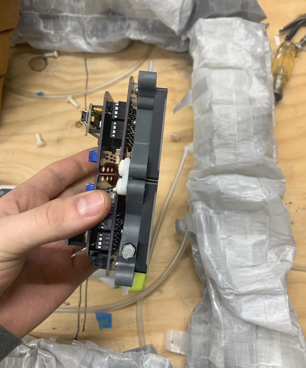 Assembled manifold held next to soft robotic sculpture