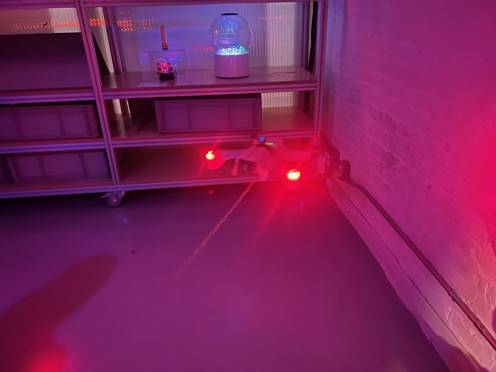 Drone in flight close-up with magenta stage lighting