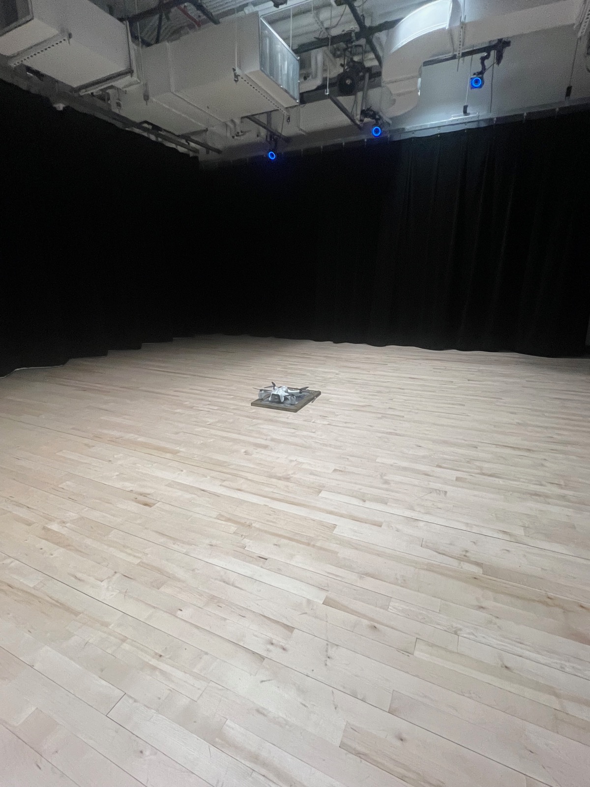 Drone on stage in black box theater before performance